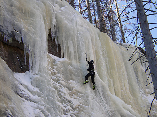 Ice climbing in winter in a mountain valley